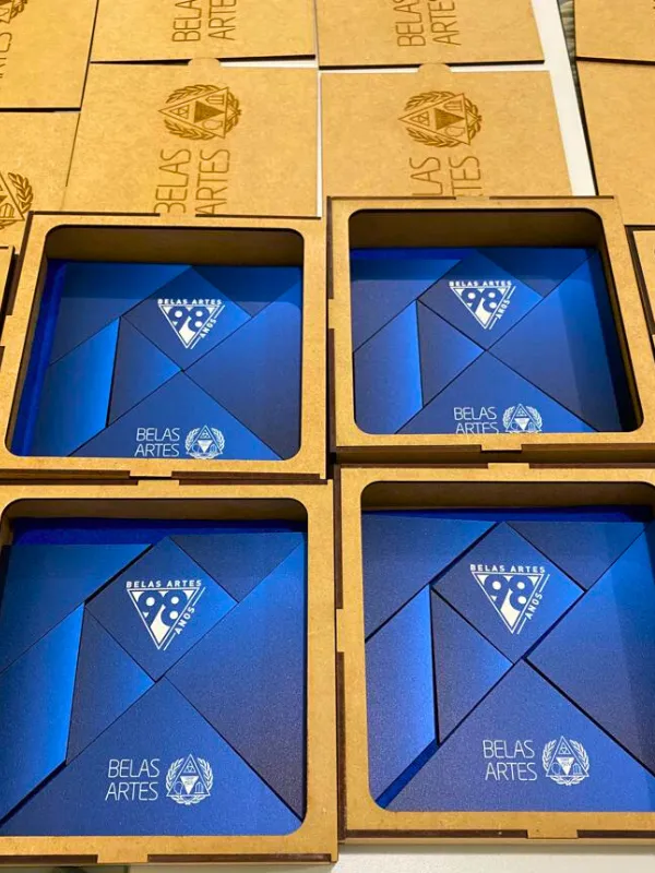Caixas em MDF gravadas com o logo de 98 anos da Belas Artes